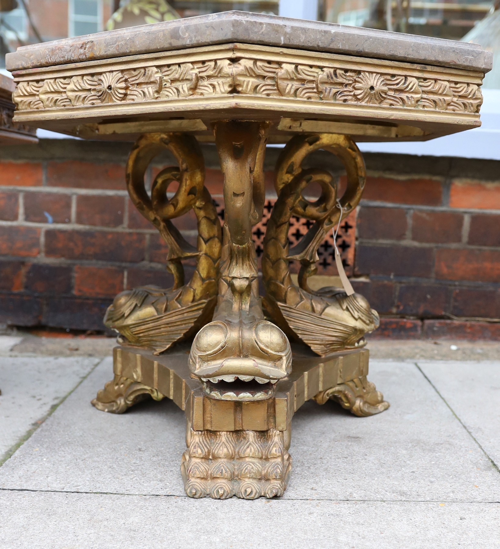 A near pair of 1960’s Italian carved giltwood occasional tables, with hexagonal marble tops and stylised dolphin underframes, height 48cm. width 66cm